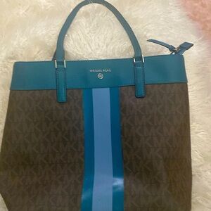 MK brown letters. Teal and light blue stripes
